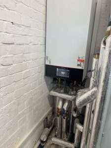 Viessmann unit with foil-lagged pipework below it in a cupboard